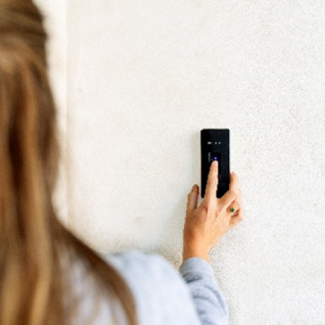 A girl using a fingerprint scan to open door demonstrating access controls