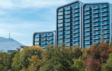 The A3 Advanced Architecture Apartments residential buildings, rising behind trees in Bulgaria.